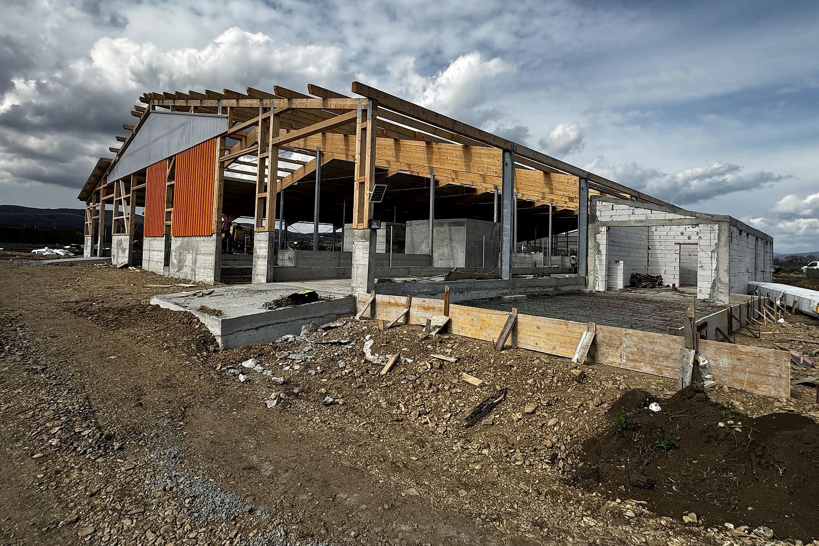 Structura grajdului în construcție, sub un cer cu nori