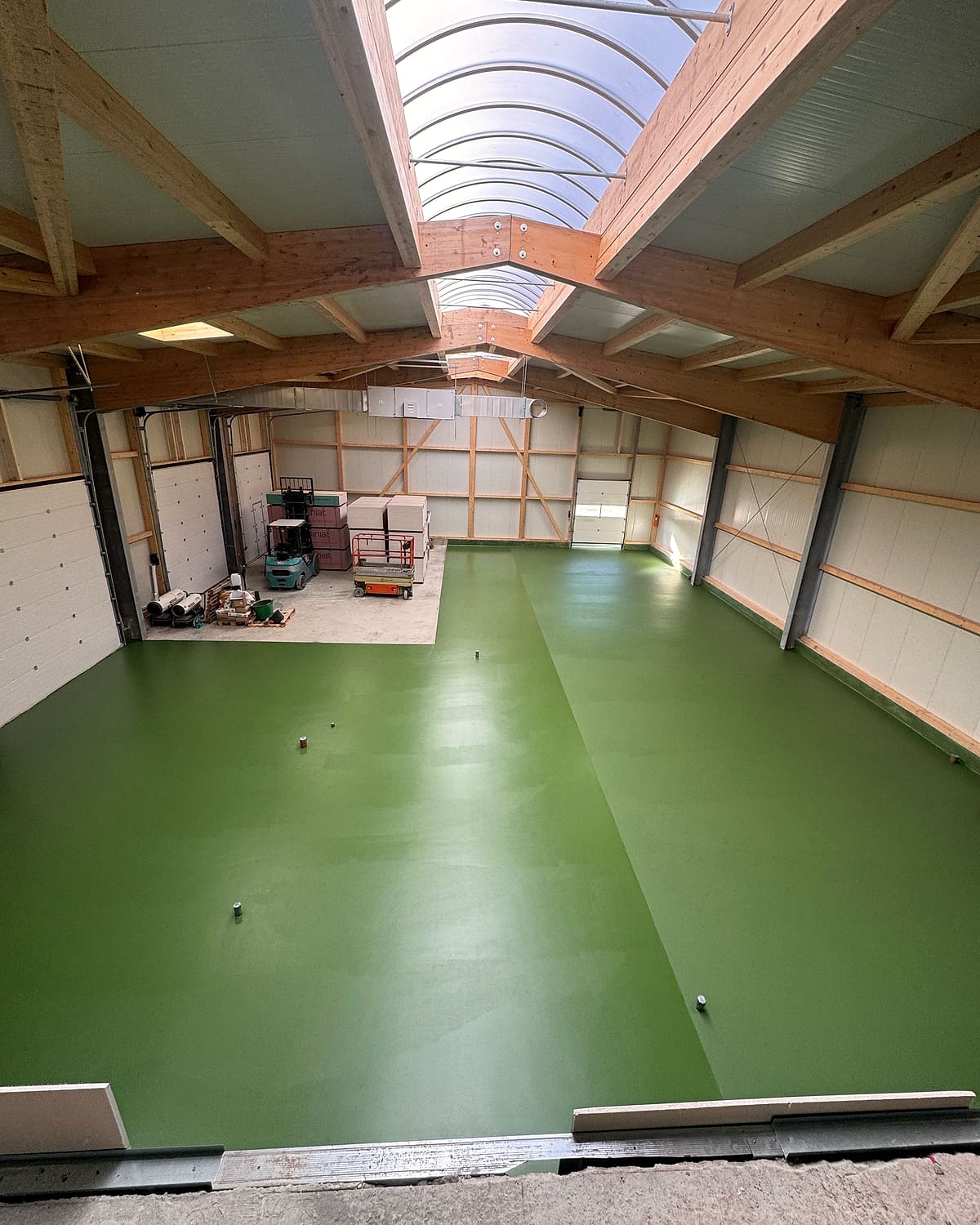 Hala goală a unității Bio Carpathia, cu pardoseală verde și lumină de sus